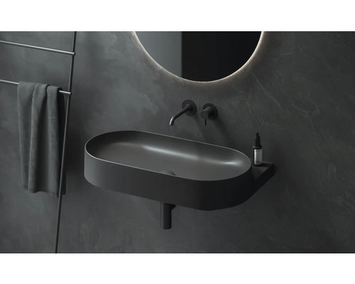 Moderní koupelna s podlouhlým umyvadlem na desku, vodovodní baterií, zrcadlem a držákem na ručníky.