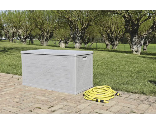 Šedý zahradní box s žlutou zahradní hadicí na zahradě