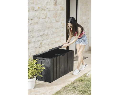 Žena otevírá černý zahradní box pro venkovní skladování