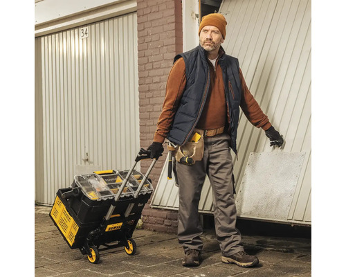 Řemeslník s vozíkem na nářadí před garáží