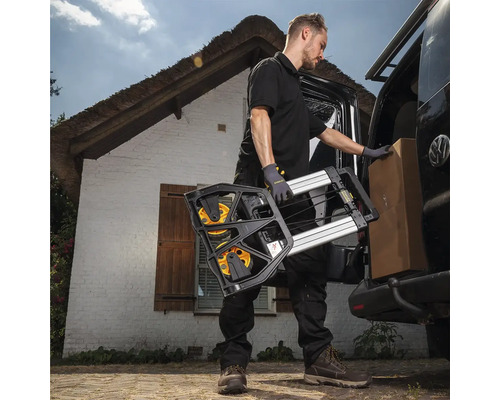 Muž vykládá rudl a krabici z dodávky před domem