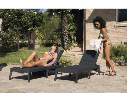 Dvě ženy relaxují na lehátkách na zahradě.