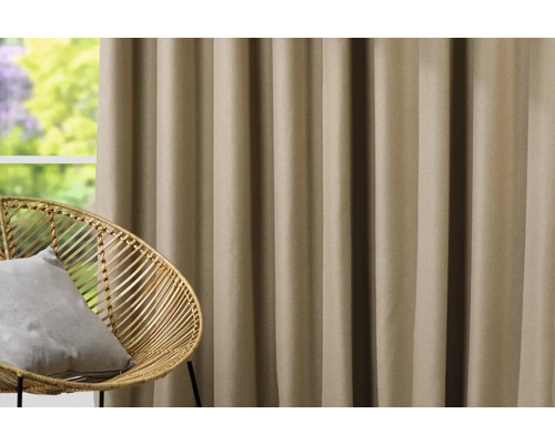 Dekorativní závěs vedle ratanového křesla před oknem