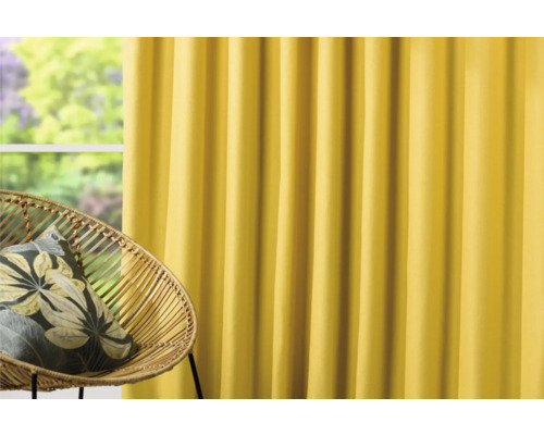 Dekorativní šály se závěsem na skládací pásku a židlí z ratanu před oknem