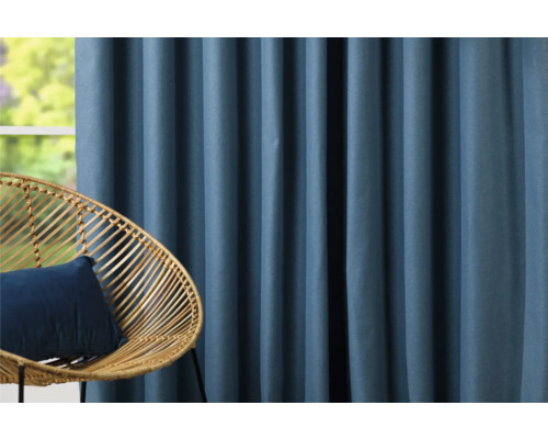 Dekorativní modré závěsy vedle ratanového křesla