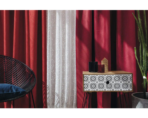 Dekorativní interiér s červenými závěsy, průsvitnými záclonami, odkládacím stolkem a posezením