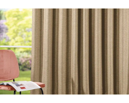 Béžový závěs vedle židle s časopisem.