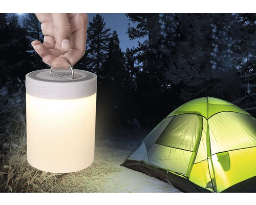 Scéna s rukou držící kempingovou lampu a stan venku