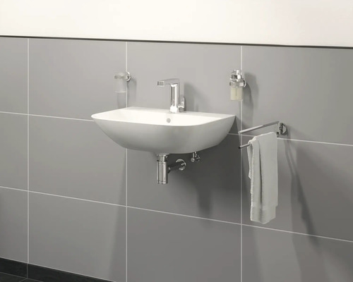 Umyvadlo s baterií, dávkovačem mýdla, kelímkem na zubní kartáčky a držákem na ručníky na šedé zdi