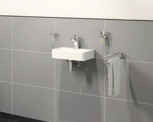 Světlá koupelna s obdélníkovým umyvadlem, baterií, držákem na ručníky, dávkovačem mýdla a kelímkem na zubní kartáčky