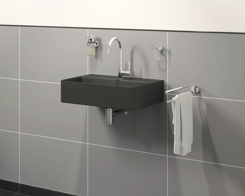 Moderní koupelna s černým umyvadlem, baterií, dávkovačem mýdla, kelímkem na zubní kartáčky a držákem na ručníky