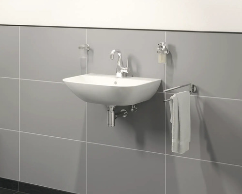 Moderní koupelna s umyvadlem, vodovodní baterií, dávkovačem mýdla a držákem na ručníky na stěně.