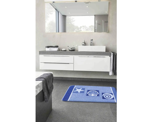 Koupelna s umyvadlem, zrcadlem a modrou koupelnovou předložkou s námořnickými motivy