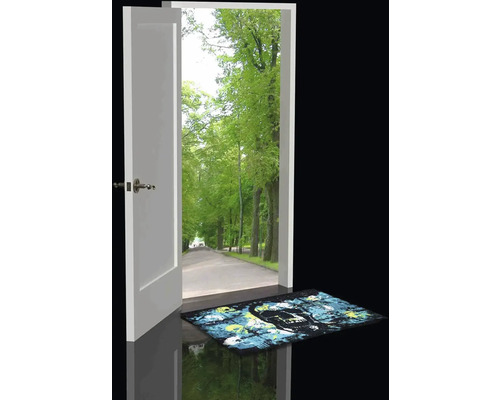 Otevřené dveře s výhledem na alej stromů a rohožka s motivem lebky