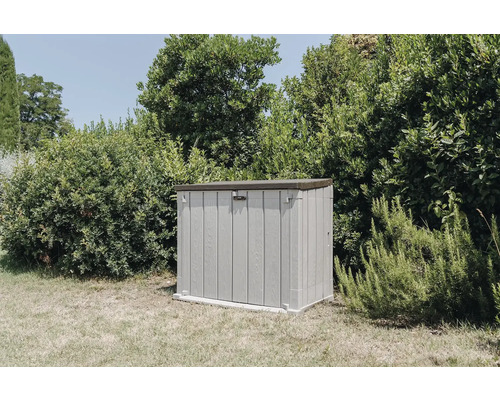 Plastová zahradní skříňka venku před zelenými rostlinami