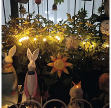 Dekorativní zahradní scéna s králičími figurkami, slunečnicovou ozdobou a světelným řetězem