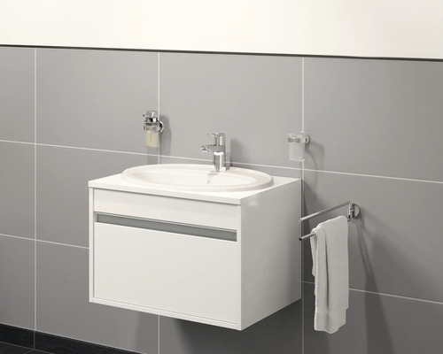 Moderní koupelna s bílou skříňkou pod umyvadlo, umyvadlem, dávkovačem mýdla, kelímkem na zubní kartáčky a držákem na ručníky