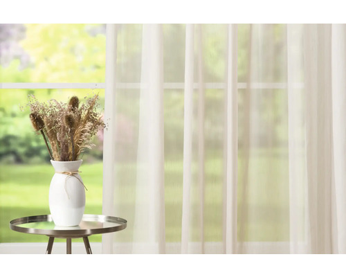 Scéna se záclonou, stolem a vázou se sušenými květinami
