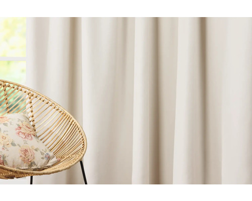 Dekorativní šály před oknem s ratanovým křeslem a polštářem