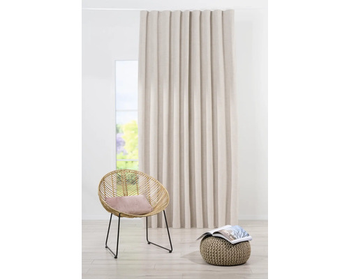 Dekorativní závěs vedle křesla a stoličky ve světlé místnosti.