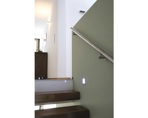 Schodiště s dřevěnými schody, nerezovým zábradlím a nástěnným svítidlem