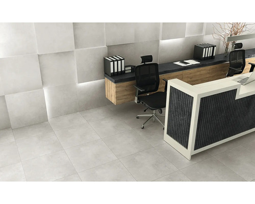 Scéna se světle šedou dlažbou, recepcí a kancelářským nábytkem.