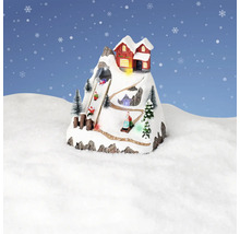 Dekorativní zimní krajina s horskou chatou a sáňkaři