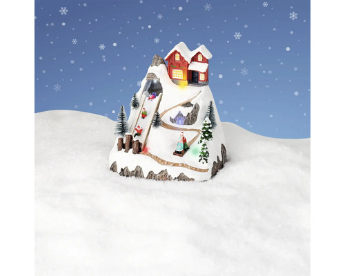 Dekorativní zimní krajina s horskou chatou a sáňkaři