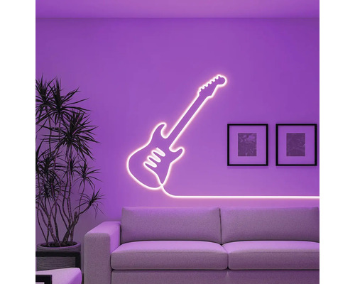 Dekorativní neonové světlo ve tvaru kytary na zdi nad pohovkou