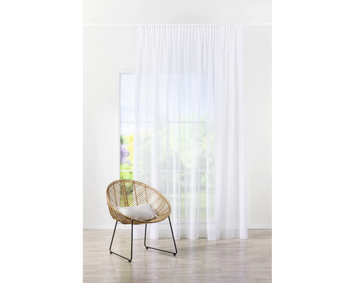 Scéna s bílým závěsem, oknem a ratanovým křeslem