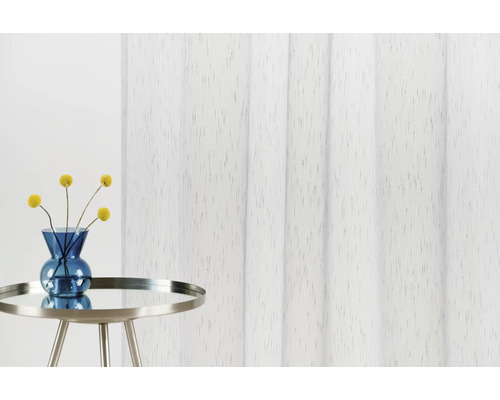 Dekorativní látkový panel vedle stolu s květinami ve váze