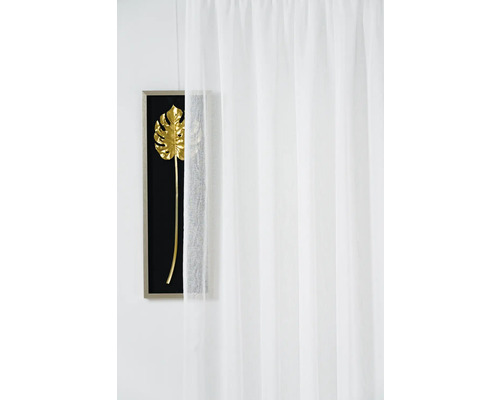 Bílý závěs před nástěnnou dekorací