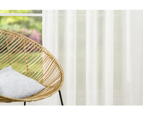 Dekorativní obývací pokoj s ratanovým křeslem a průhledným závěsem
