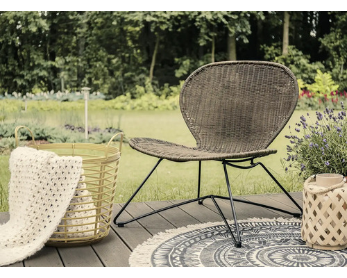 Zahradní scéna s ratanovým křeslem, kobercem a dekorací