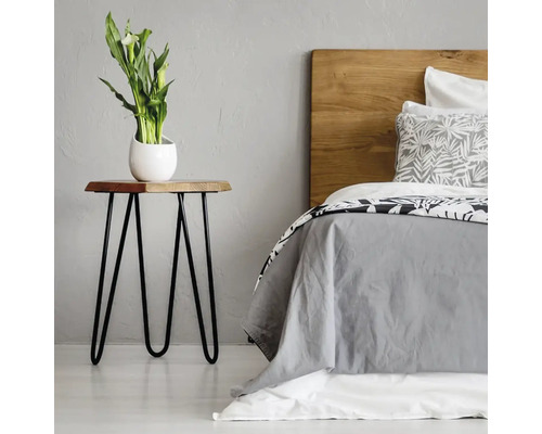 Ložnice s postelí, dřevěným nočním stolkem a vázou na květiny