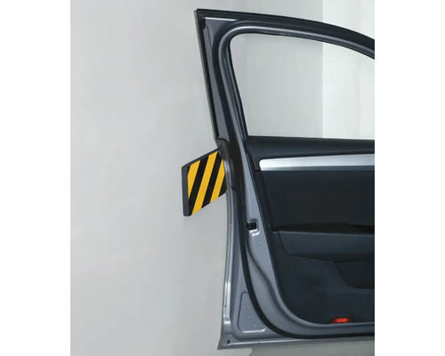 Otevřené dveře auta před stěnou s ochranou proti nárazu