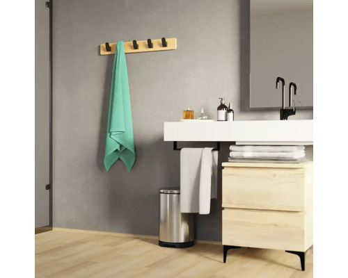 Moderní koupelna s umyvadlem, držákem na ručníky s ručníkem a odpadkovým košem