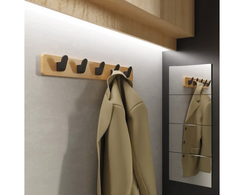 Šatna s dřevěnou deskou a několika háčky, vedle zrcadlo s odrazem bundy