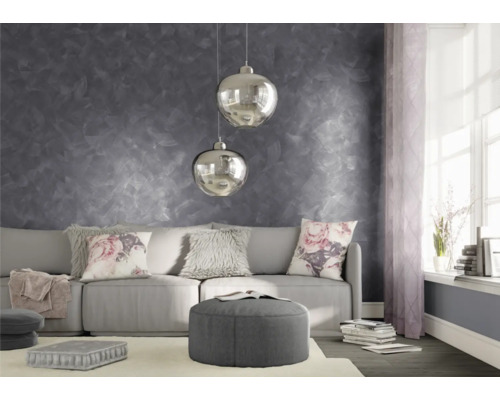 Obývací pokoj s šedou nástěnnou dekorací, pohovkou, polštáři a závěsnými lampami