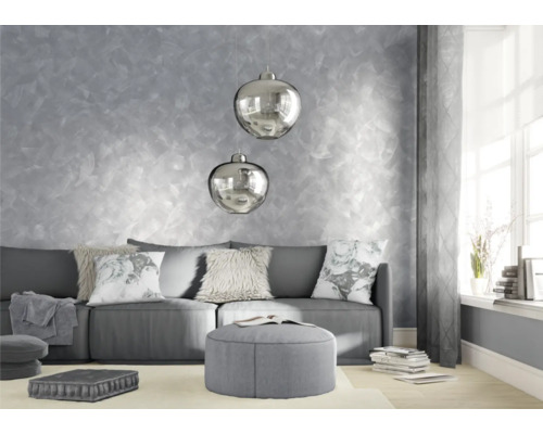 Obývací pokoj s pohovkou, polštáři, stoličkou a dekorativní nástěnnou malbou.