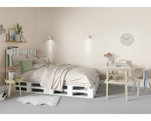 Ložnice s postelí z dřevěných palet, psacím stolem a židlí