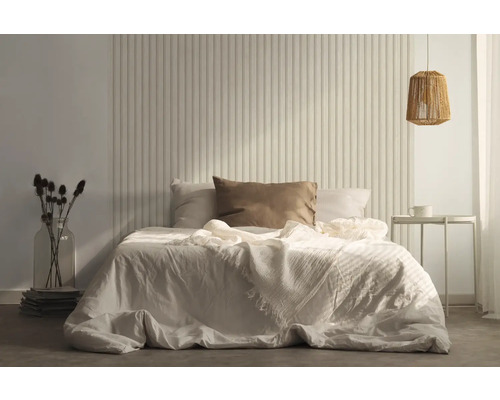 Ložnice s postelí, nočním stolkem a dekorativním obkladem stěn