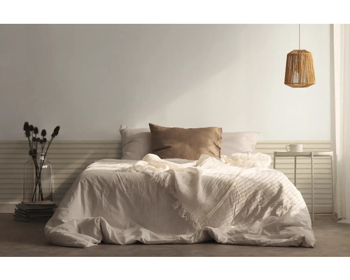 Ložnice s postelí, polštáři, přehozem, nočním stolkem a lampou