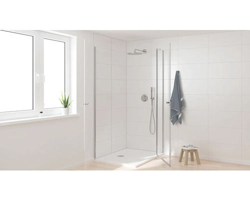 Světlá koupelna se sprchovým koutem, dešťovou sprchou a bílými dlaždicemi.