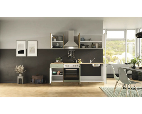 Kuchyně s umyvadlem, sporákem, digestoří a závěsnými skříňkami v světlém pokoji.