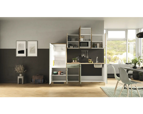 Kompletní kuchyňská linka s chladničkou, dřezem, mikrovlnnou troubou a skříňkami v jasném, moderním designu kuchyně.