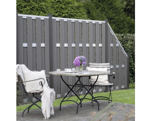 Zahrada s dřevěným plotem a posezením se stolem a židlemi