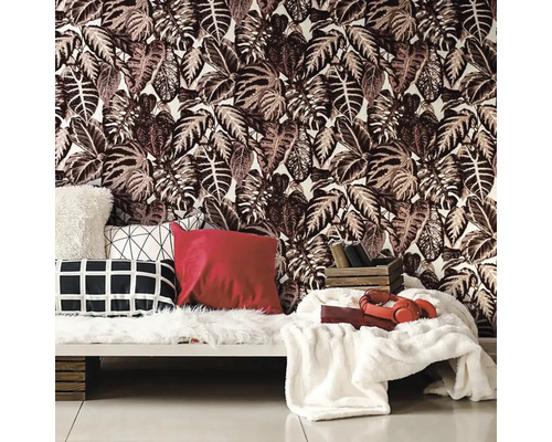 Obývací pokoj s tapetou s listovým vzorem a dekoračními polštáři na pohovce