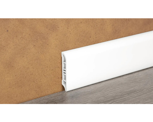Bílá plastová soklová lišta na zdi