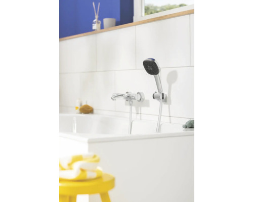 Fotografie koupelny s vanou, armaturou a ruční sprchou